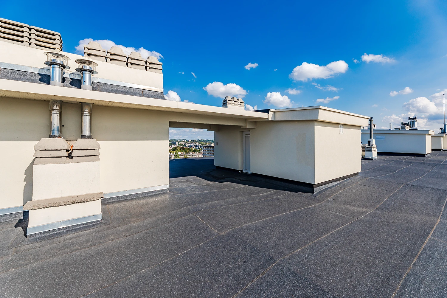 Toiture plate rénovée avec revêtement étanche et chemin technique