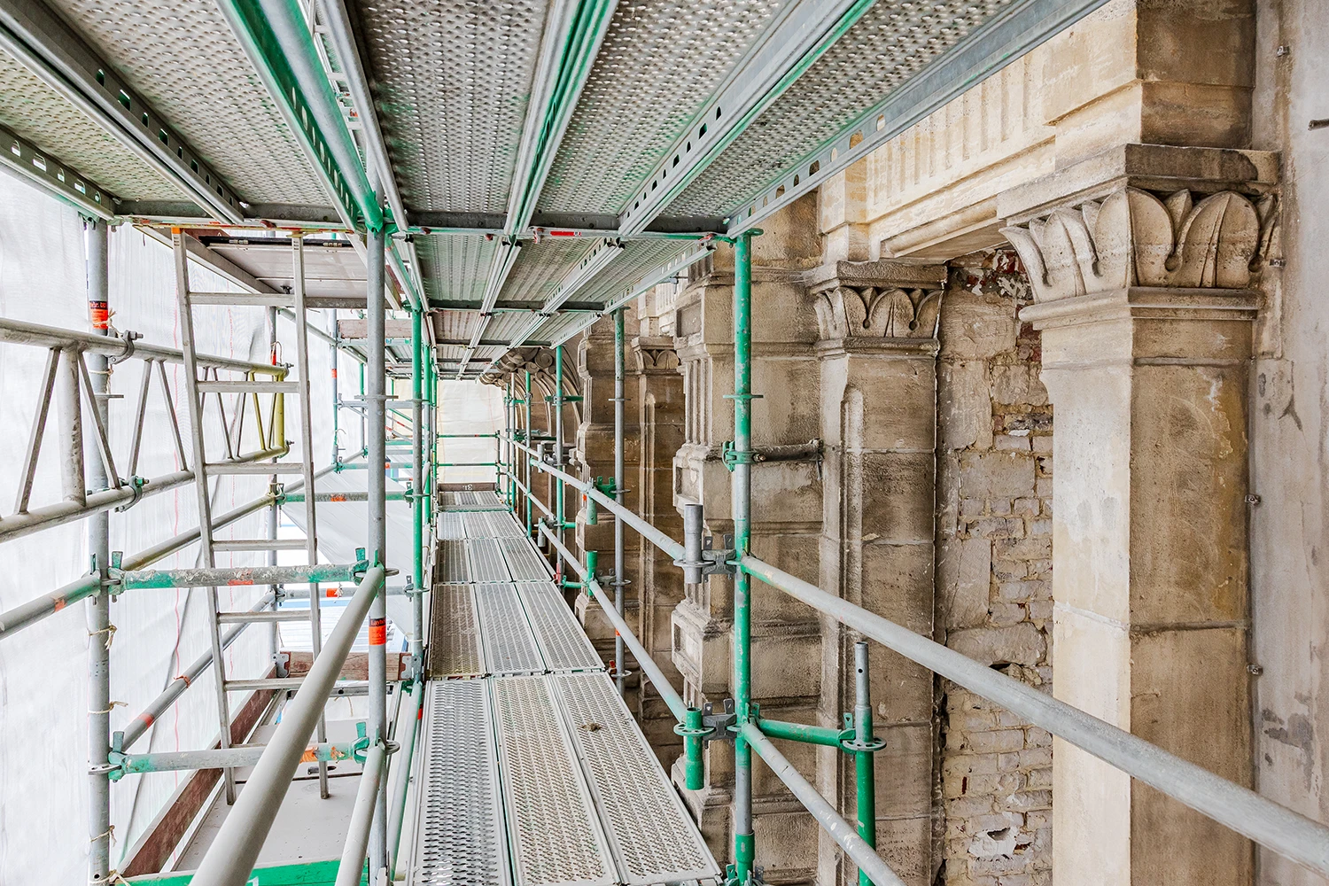 Rénovation de façade en pierre naturelle avec échafaudage sécurisé à Bruxelles